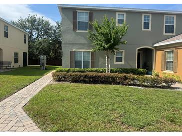 Well-maintained townhouse with green lawn, neat landscaping, and inviting walkway to covered entry at 2940 Tanzanite Ter, Kissimmee, FL 34758