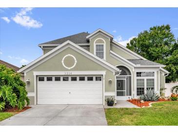 Charming home with a two-car garage and well-maintained landscaping offers great curb appeal at 3214 Herons Point Cir, Kissimmee, FL 34741