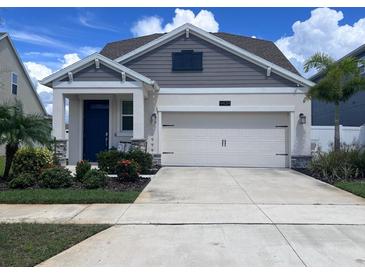 Charming single-Gathering home featuring a two-car garage, well-maintained landscaping, and a welcoming blue front door at 4424 Seven Canyons Dr, Kissimmee, FL 34746