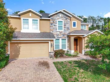 Inviting two-story home showcasing a beautiful stone facade and a well-manicured front yard at 771 Cavan Dr, Apopka, FL 32703