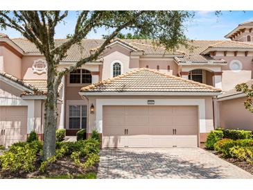 Charming townhome featuring a well-maintained tile roof, two-car garage, and beautifully landscaped front yard at 8401 Riverdale Ln # 8401, Davenport, FL 33896