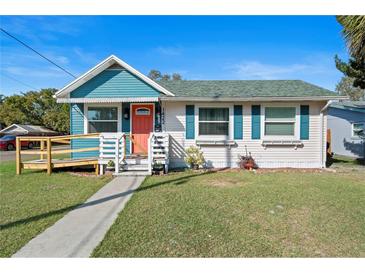 Charming single-story home with a manicured lawn, inviting walkway, and eye-catching orange door at 1422 Indiana Ave, St Cloud, FL 34769