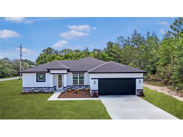 Beautiful new home with black trim, stone accents, well manicured lawn, and 2-car garage at 14967 Sw 43Rd St, Ocala, FL 34473