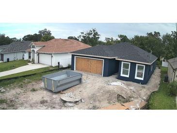 New construction home featuring a dark blue exterior, white trim, and an unfinished yard at 1522 Pine St, Orlando, FL 32824