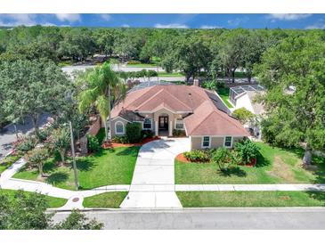Stunning single-story home boasting lush landscaping, a circular driveway, and a tile roof at 2402 Raven Croft Ct, Orlando, FL 32837