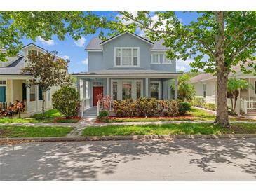 Charming two-story home featuring a welcoming front porch and lush landscaping at 6905 Beargrass Rd, Harmony, FL 34773