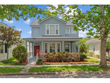 Charming two-story home with a front porch, landscaped yard, and a vibrant red door at 6905 Beargrass Rd, Harmony, FL 34773