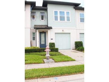 Charming two-story home with a well-manicured lawn and an attached one car garage at 721 Benoi Dr, Davenport, FL 33896