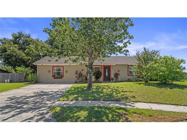 Charming single-story home featuring a well-maintained lawn and colorful landscaping at 8733 Catbriar Ln, Orlando, FL 32829