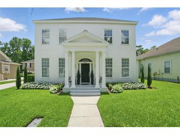 Classic two-story white home with columns, landscaped front yard, and inviting entrance at 933 Jasmine St, Celebration, FL 34747
