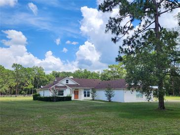 Charming single-story home with orange front door and a well-manicured lawn on a sunny day at 1781 Terra Verde Ln, Chuluota, FL 32766