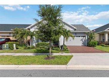 Charming single-story home with manicured landscaping, a brick driveway, and a two-car garage at 2772 Southland St, St Cloud, FL 34772