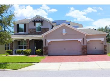 Charming two-story home with a three car garage, stone accents, and a well-manicured lawn at 2805 Carter Grove Ln, Kissimmee, FL 34741