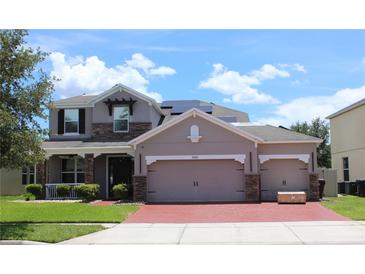 Charming two-story home with a brick driveway and stone accents, plus a three-car garage for ample parking at 2805 Carter Grove Ln, Kissimmee, FL 34741