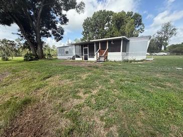 Exterior view of home with screened porch and grassy lawn at 3050 Old Soldier Rd, Lakeland, FL 33810