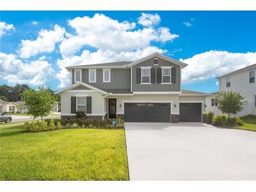Charming two-story home featuring a three car garage, manicured lawn, and impeccable landscaping at 31792 Broadwater Ave, Leesburg, FL 34748