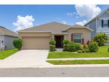 Charming single-story home with a well-manicured lawn and a two-car garage at 371 Pinecrest Loop, Davenport, FL 33837