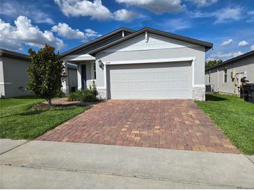 Charming single-story home with a brick driveway and attached two-car garage at 3839 Marbella Way, Davenport, FL 33897