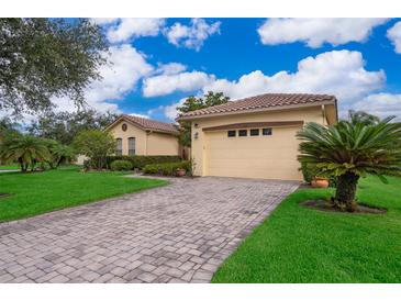 Beautiful home with a well-manicured lawn, tiled roof, and paved driveway at 730 Villa Park Rd, Poinciana, FL 34759