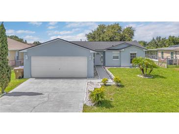 Charming single-story home featuring a two-car garage and well-manicured front yard at 107 Whitehall Way, Kissimmee, FL 34758