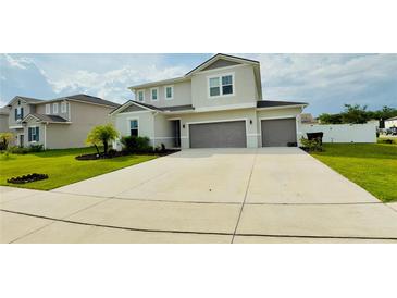Two-story home featuring a light gray exterior, well-manicured lawn, and an attached two-car garage at 2508 W End Dr, St Cloud, FL 34772