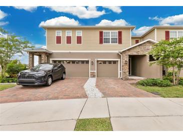 Inviting two-story home featuring a brick driveway and a two-car garage at 2690 Pleasant Cypress Cir, Kissimmee, FL 34741