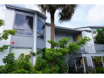 Two-story condo with palm tree, staircase entry, and ample greenery at 4378 Aqua Vista Dr # L, Orlando, FL 32839