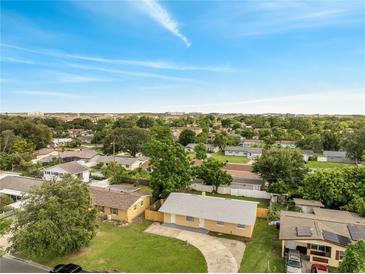 An aerial view of a charming neighborhood featuring well-maintained homes and lush greenery under a blue sky at 4521 Alrix Dr, Orlando, FL 32839
