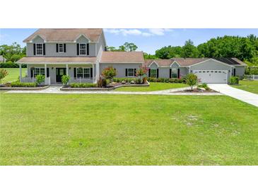 Charming two-story home with a welcoming front porch and lush green lawn at 4551 Hunting Lodge Dr, St Cloud, FL 34772