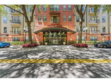 Elegant condo building entrance featuring modern glass doors, landscaping, and clear signage for Uptown Place at 911 N Orange Ave # 321, Orlando, FL 32801