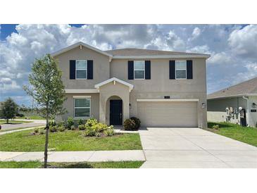 Charming two-story home with a well-maintained lawn, two car garage and black window shutters at 1343 Lassen St, Haines City, FL 33844