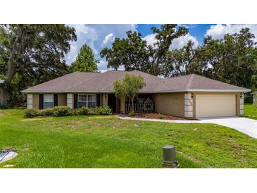 Charming single-story home with a well-manicured lawn and a two car garage at 1405 Ashbury Ct, Lakeland, FL 33809