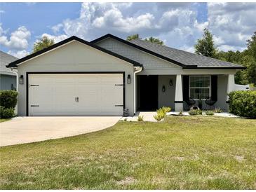 Charming single-story home with a well-manicured lawn and a two-car garage, showcasing inviting curb appeal at 144 Foxtail Loop, Davenport, FL 33837