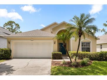 Charming single-story home featuring a two-car garage, manicured lawn, and tropical landscaping at 2263 Mallory Cir, Haines City, FL 33844