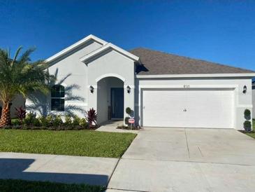 Charming single-story home with a well-manicured lawn and a two-car garage on a sunny day at 820 Cambridge Dr, Winter Haven, FL 33881