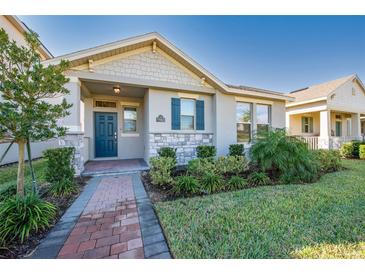 Charming single-Gathering home featuring stone accents, a covered porch, and well-maintained landscaping at 11051 Bostwick Aly, Winter Garden, FL 34787