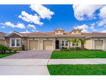 Charming home featuring a tile roof, two-car garage, and manicured landscaping at 1173 Trappers Trail Loop, Champions Gate, FL 33896