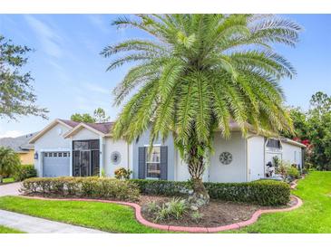 Charming single-story home with a well-manicured lawn, lush landscaping, and inviting curb appeal at 125 Prima Dr, Poinciana, FL 34759