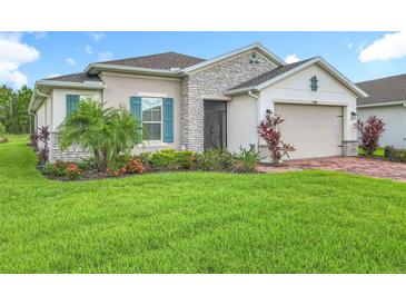 Well-maintained home featuring manicured landscaping and a charming combination of stone and stucco exterior at 159 Olympus Way, Kissimmee, FL 34759