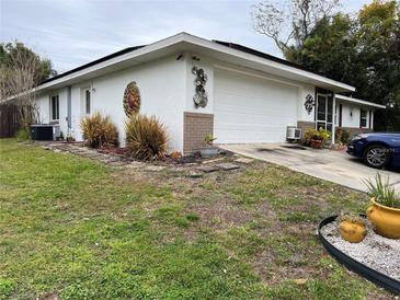 Charming home featuring a two-car garage, decorative wall art, and a well-maintained, partially landscaped front yard at 2346 Greenbrier St, Deltona, FL 32738