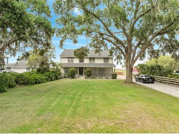 Charming two-story home features a large, well-maintained lawn and mature trees at 2525 Ridgeway Dr, Kissimmee, FL 34746