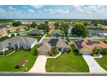 Inviting single-story home showcasing solar panels, a two-car garage, and a meticulously maintained lawn at 301 Terranova Blvd, Winter Haven, FL 33884