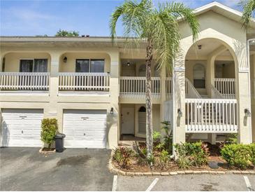 Inviting exterior of a two-story condo with palm tree, private garage, and balconies on both floors at 3205 Sabal Palms Ct # A, Kissimmee, FL 34747