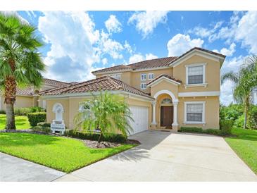 Two-story home with terra cotta roof, attached garage, well-manicured lawn, and ample driveway space at 344 Cherokee Ave, Haines City, FL 33844