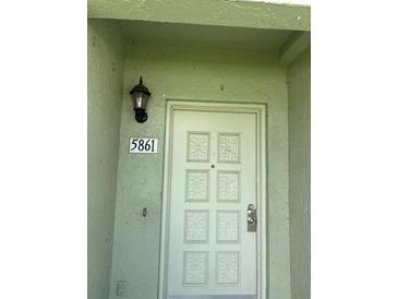 Inviting front door with stylish details and a secure entrance; home address displayed above at 5861 La Costa Dr # 115, Orlando, FL 32807