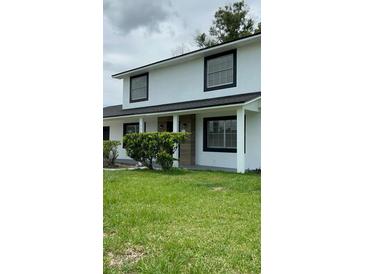 Charming two-story home with a well-maintained lawn and stylish black-framed windows at 124 Cinnamon Dr, Orlando, FL 32825