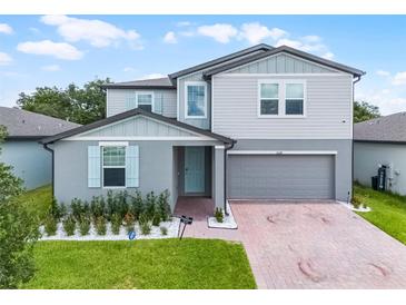 Charming two-story home with light-blue shutters, attached garage, and well-manicured lawn at 1538 Mermaid Way, Haines City, FL 33844