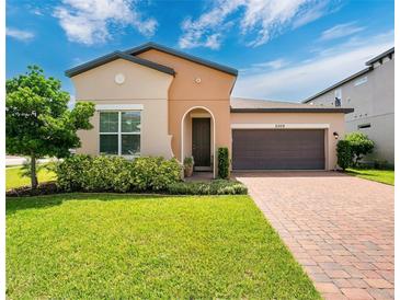 Charming one-story home with a two-car garage, beautiful landscaping, and a brick driveway at 2009 Napoli Dr, St Cloud, FL 34771