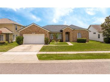 Charming single-story brick home featuring a well-manicured lawn and attached two-car garage at 2547 Raccoon Run Ln, Orlando, FL 32837
