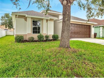 Charming home featuring a well-maintained lawn, two car garage, and mature trees at 2810 Maguire Dr, Kissimmee, FL 34741